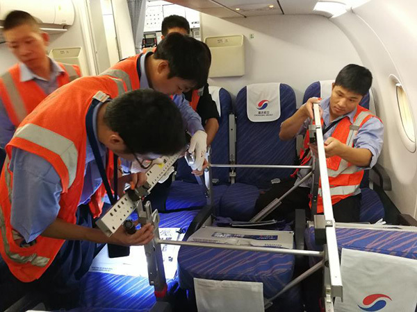 Staff from Chongqing Airlines dismantle passenger seats on a plane to make room for a stretcher that used to transport a patient from Tibet to Chongqing on September 8, 2017. [Photo courtesy of Chongqing Airlines]