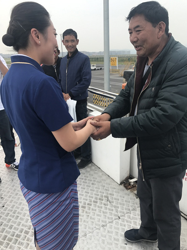 The family member of the Tibetan patient who was transported on a plane from Tibet to Chongqing thank the crew upon landing at the Chongqing Jiangbei Airport on September 8, 2017. [Photo courtesy of Chongqing Airlines]