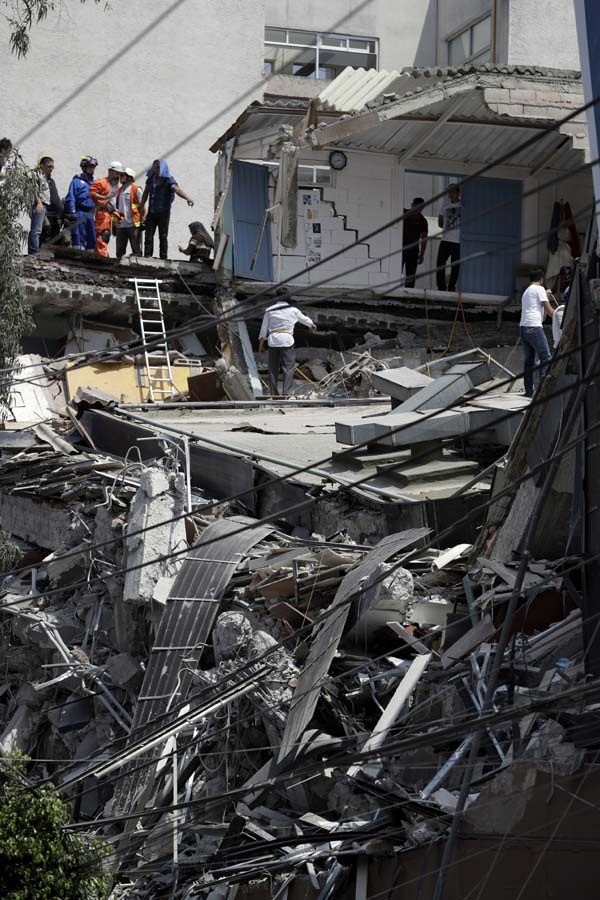 Rescue workers and volunteers search a building that collapsed after an earthquake in downtown Mexico City, Tuesday, Sept. 19, 2017. A powerful earthquake jolted central Mexico on Tuesday, causing buildings to sway sickeningly in the capital on the anniversary of a 1985 quake that did major damage. [Photo: AP]