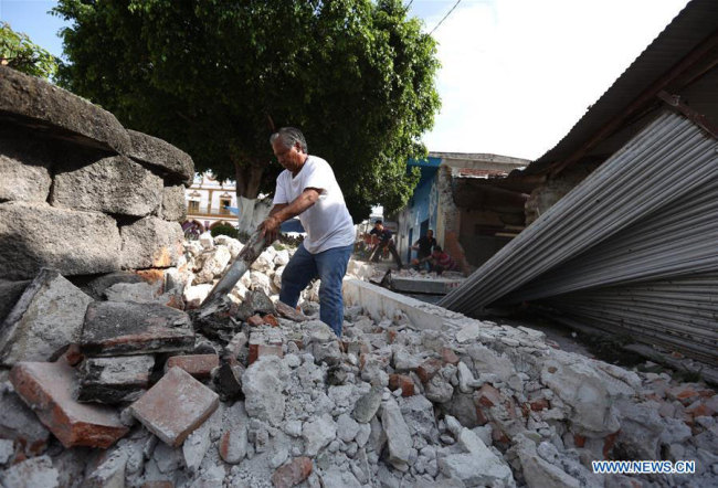 A resident removes debris on a collapsed building in Jojutla, the state of Morelos, Mexico, on Sept. 20, 2017. [Xinhua/Armando Solis]