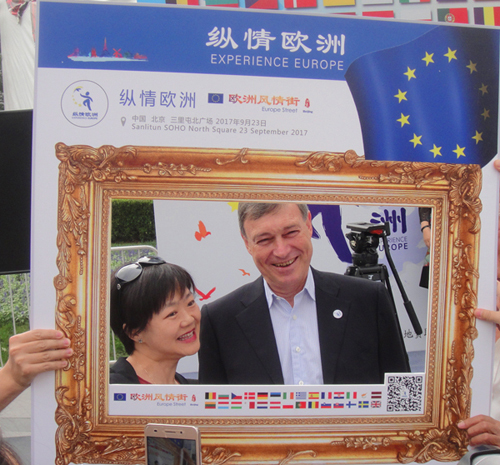 EU Ambassador to China Hans Dietmar Schweisgut takes a photo with a visitor at the "Europe Street" event held on Saturday, September 23, 2017 in Beijing. [Photo: China Plus]