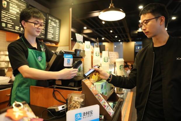 A customer uses the Alipay mobile app to make a purchase at a Starbucks outlet. [Photo: via Alipay]