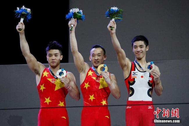 Chinese gymnasts Xiao Ruoteng (C), Lin Chaopan (L) and Japanese gymnast Shirai Kenzo pose for photos during the awards ceremony in the men's all-around at the Artistic Gymnastics World Championships in Montreal, Canada on Thursday, October 5, 2017. [Photo: Chinanews.com]