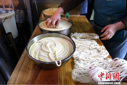 A single hand-pulled noodle is 20-meters long at Lan Jianbo’s restaurant in Xi’an, northwest China’s Shaanxi Province, on November 2, 2017. [Photo: Chinanews.com]