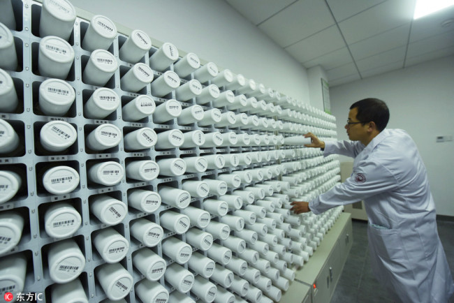 A Traditional Chinese Medicine (TCM) physician dispenses medicine with the help of an artificial intelligence (AI) diagnosis system in Wuzhen, Zhejiang Province on November 25, 2017. Instead of traditional wooden medicine cupboards, he stands in front of high-tech white "pots" which can automatically prepare convenient traditional medicines within 10 minutes. [Photo: IC]