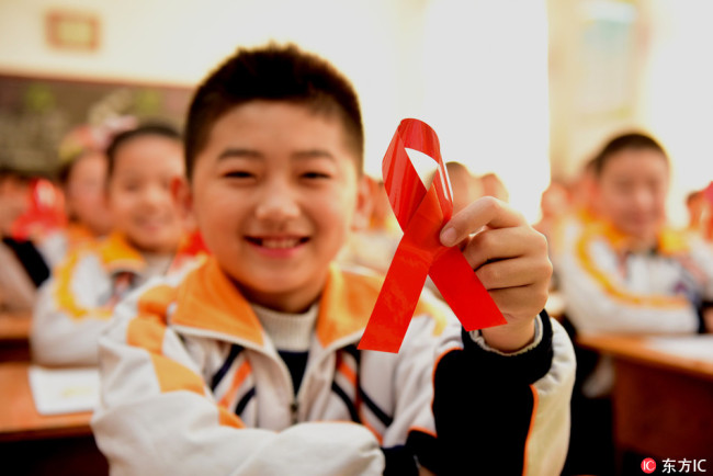 A student from a primary school in Shijiazhuang, Hebei Province demonstrates a red ribbon made by himself on November 30, 2017. [Photo: IC]