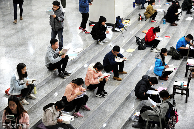 Students sit on the stairs studying for the national postgraduate entrance exams in Wuhan, capital city of Hubei Province on November 25, 2017. [Photo: VCG]