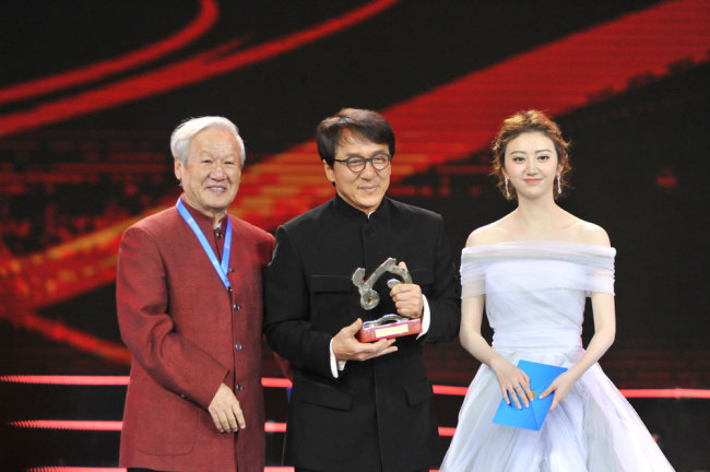 Chinese director Xie Fei (left), action star Jackie Chan (center), actress Jing Tian (right) attend the closing ceremony of the Silk Road International Film Festival on December 3, 2017 in Fuzhou, Fujian Province.[Photo: China Plus]