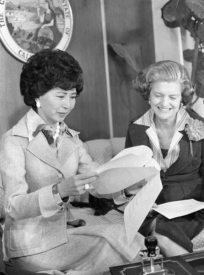 California Secretary of State March Fong Eu (left), with first lady Betty Ford, checks the names of delegates pledged to President Gerald Ford in the California primary election, after putting her stamp of approval on them in her Sacramento office in California, May 5, 1976. [File Photo: AP]