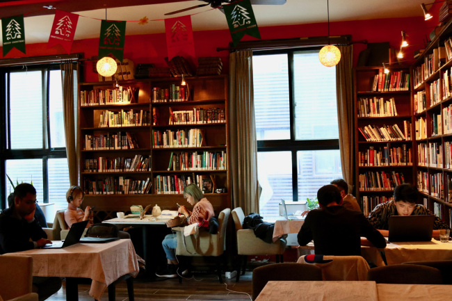 People chat and do their work at The Bookworm. [Photo: China Plus/ Li Xiang]