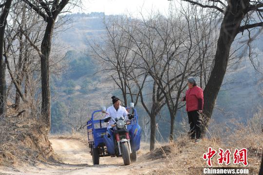Li Shuanzhou, a 57-year-old village doctor with only one leg in Shanxi Province, offers medical services to villagers at a remote village. [Photo: Chinanews.com]