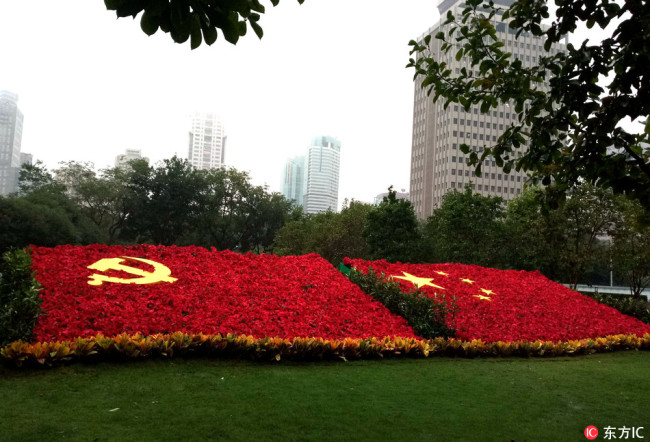 A gigantic national flag and Party flag made of flowers laid out on the green lawn in Shanghai's People's Square.[File Photo: IC]