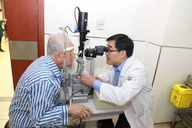 Huang Xuhua, the 93-year-old engineer behind China's first nuclear submarine, receives an eye test from Yao Yufeng, director of the ophthalmology department at Sir Run Run Shaw Hospital in Hangzhou. [Photo: Guangming Daily]