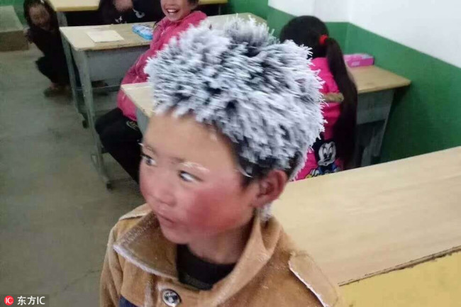 Wang Fuman arrives in class with his hair frozen after a 4.5-kilometer walk to his school in Ludian County, Yunnan Province, on January 8, 2018. [Photo: IC]