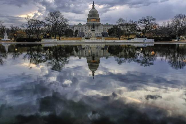 Clouds are reflected in the U.S. Capitol reflecting pool at daybreak in Washington, Monday, Jan. 22, 2018. [Photo: AP/J. David Ake]