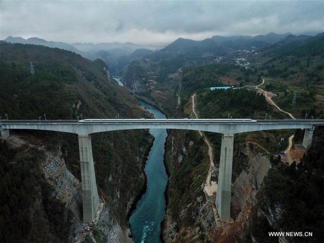 A bullet train runs through a bridge over Wujiang River, a tributary of China's longest river, Yangtze, on the Chongqing-Guiyang line in Zunyi City, southwest China's Guizhou Province, Jan. 25, 2018. A railway connecting Chongqing and Guiyang, two major cities in southwest China, started operation Thursday. Designed for trains running at a speed of 200 km per hour, the 347-km rail line will cut travel time between Chongqing and Guiyang from the current 10 hours to 2 hours, and shorten travel time between Chengdu, capital of Sichuan, and Guiyang from current 11 hours to 3.5 hours. [Photo: Xinhua] 