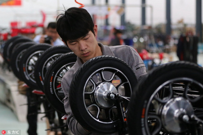 A Chinese worker assembles electric bikes at a plant in Huaian city, Jiangsu Province on May 7, 2016. [Photo: IC]