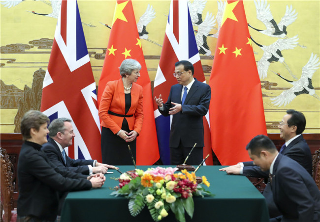 Chinese Premier Li Keqiang and visiting British Prime Minister Theresa May witness the signing of a number of bilateral cooperation documents in the fields of trade, finance, health care and smart city in Beijing on Jan. 31, 2018. [Photo: Xinhua]