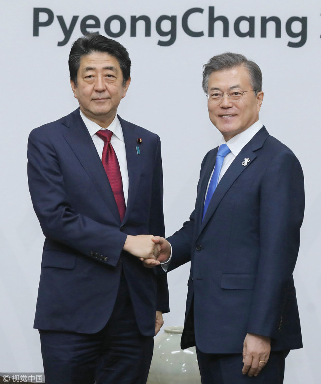 Japanese Prime Minister Shinzo Abe, left, shakes hands with South Korean President Moon Jae-in at the beginning of a meeting in Pyeongchang, South Korea, Feb. 9, 2018. [Photo: VCG]