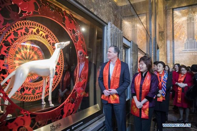 Chinese Consul General in New York Zhang Qiyue (2nd L) and John B. Kessler (1st L), President of the Empire State Realty Trust, view dog decorations to mark the Chinese Lunar Year of Dog after a ceremonial lighting ceremony in honor of the Spring Festival at the Empire State Building in New York, the United States, on Feb. 13, 2018. The top of the Empire State Building in Midtown Manhattan, New York, will shine in red and gold at sunset on Tuesday and Thursday, celebrating Chinese Lunar New Year that falls on Feb. 16 this year. [Photo: Xinhua]