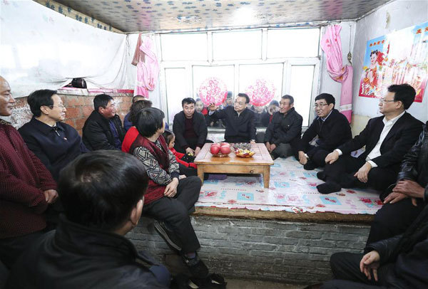Chinese Premier Li Keqiang talks with villagers as he visits impoverished families in Yinghua Village of Zhenlai County in the city of Baicheng, northeast China's Jilin Province, Feb. 12, 2018. [Photo: Xinhua/Pang Xinglei]