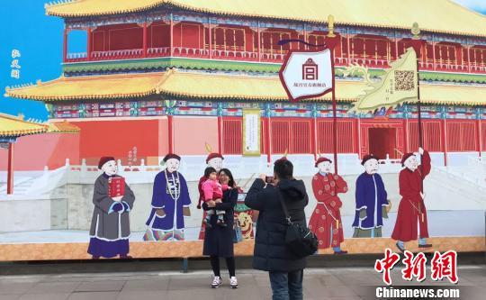 Undated photo shows visitors taking a picture of a Forbidden City-themed mural on Shanghai's famous Nanjing Road. [Photo: Chinanews.com]