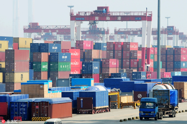 A truck drives past stacks of containers at the Port of Qingdao, east China's Shandong Province, August 8, 2013. [File Photo: IC]