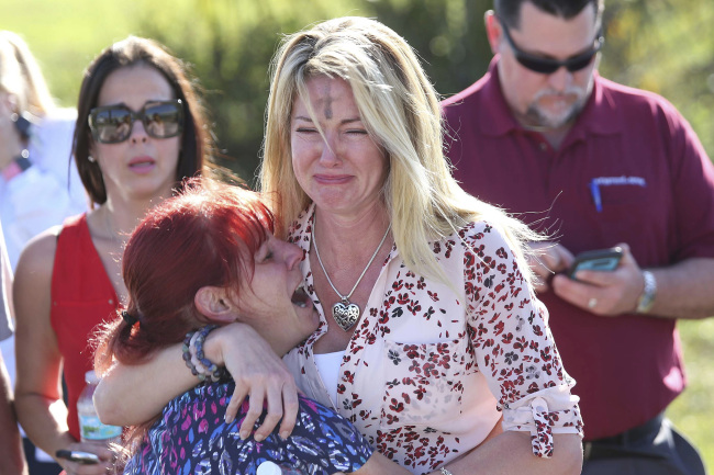 Parents wait for news after a reports of a shooting at Marjory Stoneman Douglas High School in Parkland, Fla., on Wednesday, Feb. 14, 2018. [Photo: AP Photo/Joel Auerbach]