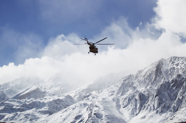 In this photo provided by Tasnim News Agency, a rescue helicopter flies over the Dena mountains while searching for wreckage of a plane that crashed on Sunday, in southern Iran, Monday, Feb. 19, 2018. [Photo: AP]