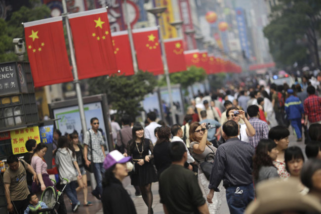 The crowd strolls on a pedestrian street in Shanghai, China, Monday, April 29, 2013.[Photo: AP/Eugene Hoshiko]