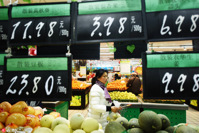 A customer shops for fruit at a supermarket in Hangzhou, Zhejiang Province, February 9, 2018. [Photo: IC]
