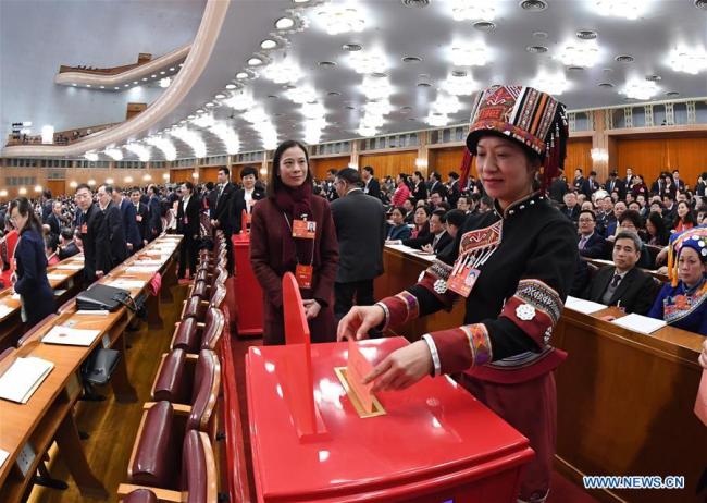 A deputy to the 13th National People's Congress (NPC) casts her ballot on a draft amendment to the country's Constitution at the third plenary meeting of the first session of the 13th NPC in Beijing, capital of China, March 11, 2018. [Photo: Xinhua/Rao Aimin]