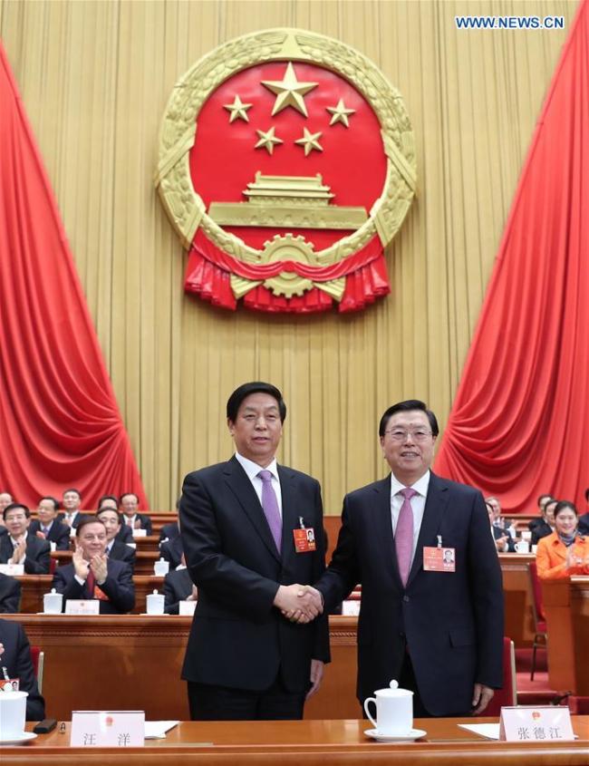 Li Zhanshu (L, front) shakes hands with Zhang Dejiang, chairman of the Standing Committee of the 12th National People's Congress (NPC), at the fifth plenary meeting of the first session of the 13th NPC at the Great Hall of the People in Beijing, capital of China, March 17, 2018. Li Zhanshu was elected chairman of the 13th NPC Standing Committee on Saturday morning at the meeting. [Photo: Xinhua]