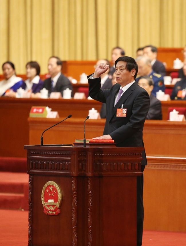 Li Zhanshu takes a public oath of allegiance to the Constitution in the Great Hall of the People in Beijing on March 17, 2018. Li Zhanshu was elected chairman of the 13th NPC Standing Committee on Saturday morning at the meeting. [Photo: Xinhua]