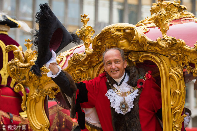 The new Lord Mayor of London Charles Bowman waves from his carriage during the parade at the Lord Mayor's Show 2017, in the City of London. [Photo: VCG]