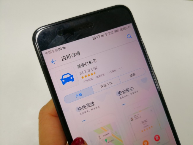 Photo taken on March 22, 2018 shows a user downloading Meituan's car-hailing app on her smartphone. [Photo: China Plus]