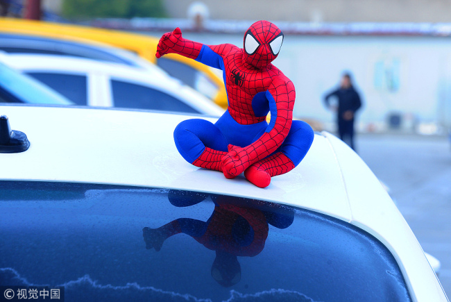 "Spiderman" sits on top of a car in Suzhou, Jiangsu Province, on December 19, 2017. [File Photo: VCG]