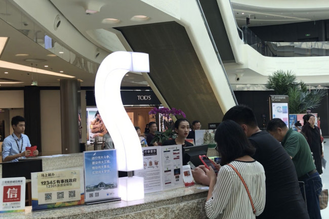 A photo shows visitors at the information desk of the China Duty Free Mall in Sanya, Hainan province, March 27, 2018. [Photo: China Plus/Ge Anna]