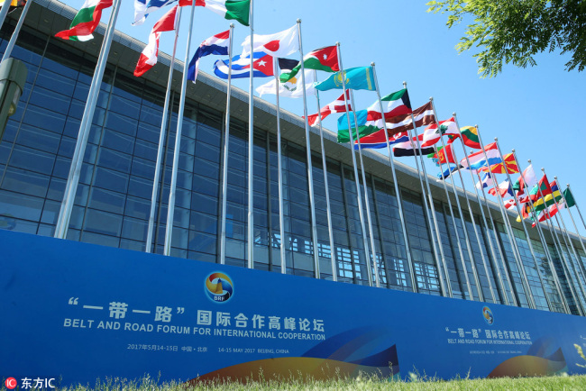 Photo taken on May 14, 2017 shows flags from numerous participating countries outside the China National Convention Center where the Belt and Road Forum for International Cooperation is held in Beijing. [Photo: IC]