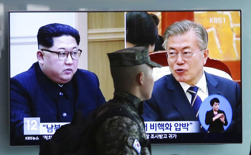 A South Korean marine soldier passes by a TV screen showing file footage of South Korean President Moon Jae-in and North Korean leader Kim Jong Un, left, during a news program at the Seoul Railway Station in Seoul, South Korea, Wednesday, April 18, 2018. North and South Korea have agreed to allow live television broadcasts for parts of the summit between North Korean leader Kim Jong Un and South Korean President Moon Jae-in next week. [Photo: AP]