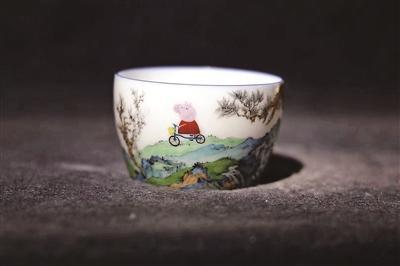 A white porcelain cup painted with the English cartoon figure Peppa Pig riding a bicycle through grassland. [Photo: Beijing Youth Daily]