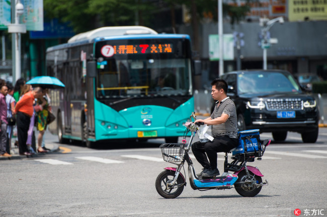 A take-out delivery driver is caught running a red light by one of 40 new cameras linked to facial recognition software in Shenzhen, April 23, 2018. [Photo: IC]