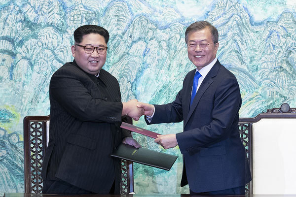 South Korean President Moon Jae-in (R) and Kim Jong Un, top leader of the Democratic People's Republic of Korea (DPRK), shake hands after signing a joint declaration, titled the Panmunjom Declaration for Peace, Prosperity and Unification of the Korean Peninsula, at Peace House on the South Korean side of Panmunjom on April 27, 2018. [Photo: VCG]