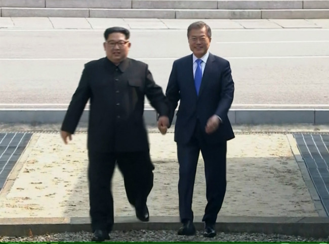 In this image taken from video provided by Korea Broadcasting System Friday, April 27, 2018, North Korean leader Kim Jong Un, left, crosses the border into South Korea, along with South Korean President Moon Jae-in for their historic face-to-face talks, in Panmunjom. [Photo: AP]