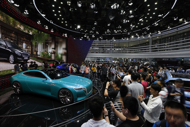 Visitors, some taking photos of a Chinese auto brand Hongqi E-Jing GT electric concept car on display at the China Auto Show in Beijing, Sunday, April 29, 2018. The auto show, which opened to the public on Sunday, continues through May 4.[Photo:AP]