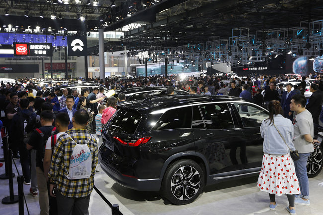 Visitors watch an electric-powered SUV manufactured by Chinese automaker NIO during the China Auto Show in Beijing, Sunday, April 29, 2018. The auto show, which opened to the public on Sunday, continues through May 4.[Photo:AP]