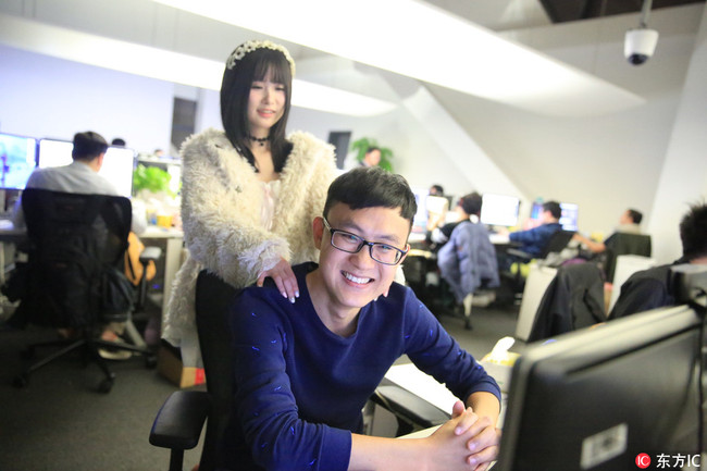 A programmer motivator massages the shoulders of a game developer at an online game producer in Shanghai, November 10, 2015. [File photo: IC]