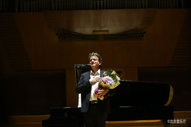 French musician Philippe LÉOGÉ receives flowers at the end of his solo jazz piano concert in Beijing on Saturday, May 5, 2018. [Photo: courtesy of Beijing Concert Hall]
