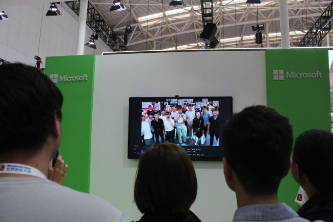 Visitors stand in front of a facial recognition camera. The camera can recognize one's age, sex and emotions. [Photo: China Plus/Guo Jing]