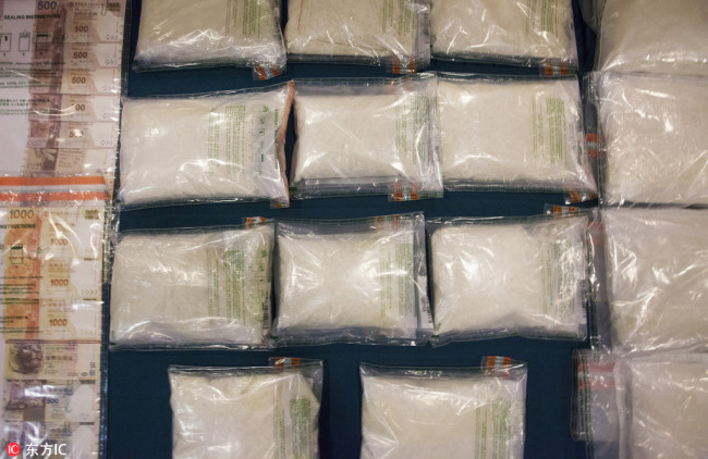 Seized bags of crystal methamphetamine, part of a haul of 32kg of methamphetamine that was busted in a raid at a flat in Hong Kong's northern town of Yuen Long on 11 May 2018, are displayed during a Hong Kong Customs and Excise Department press conference in Hong Kong, China, 13 May 2018. [Photo: IC]